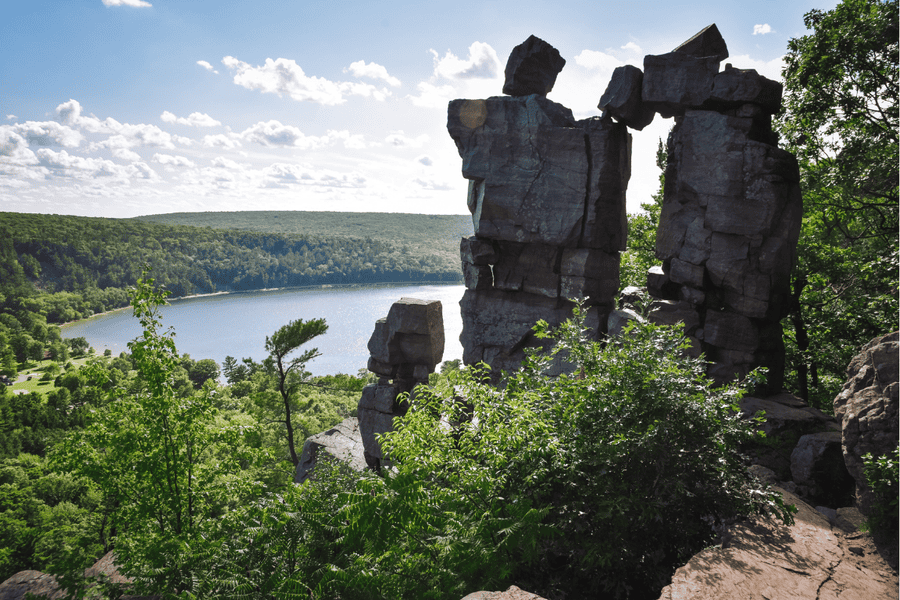 rocks stacked on each other overlooking a lake surrounded by trees