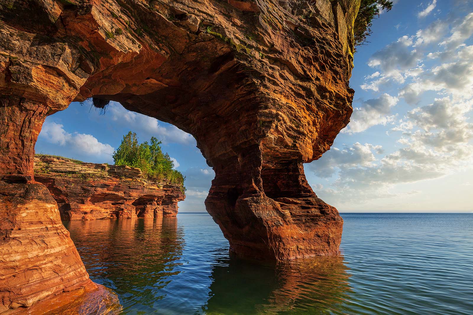 large rock formation sticking out of lake