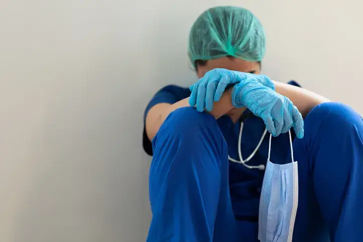 Preserving Your Patience on the Job Stressed tired healthcare worker sitting on floor
