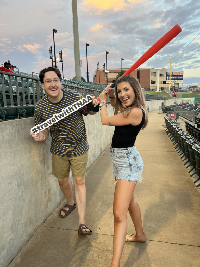 Protecting Your Pay with Paid Sick Leave TotalMed ambassadors posing with baseball bat and sign at an Arkansas Travelers game