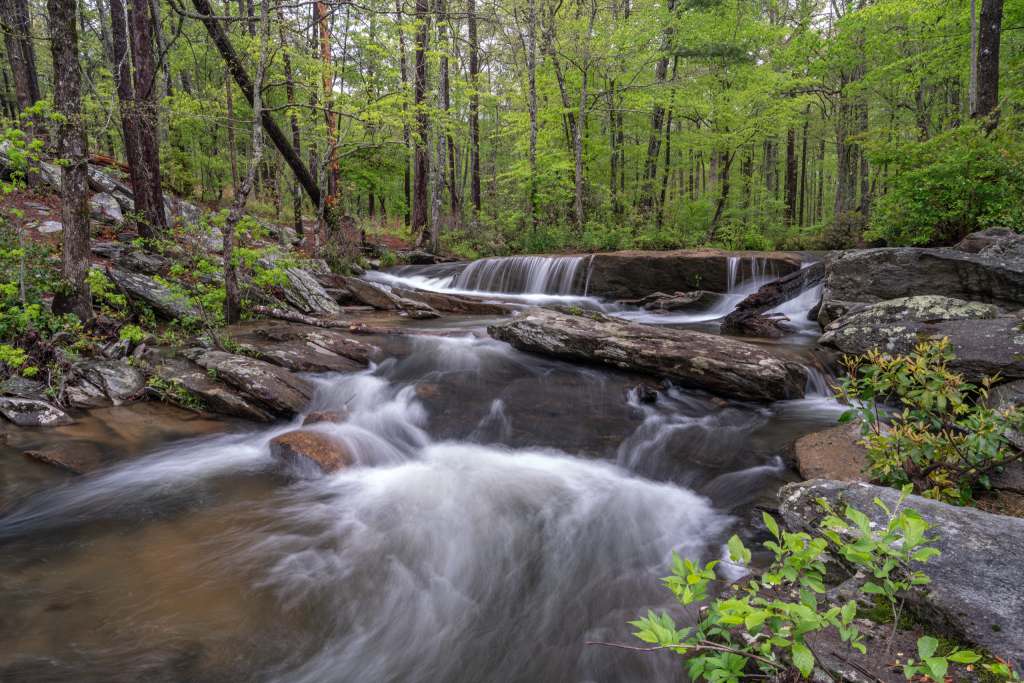 Where to Enjoy the Great Outdoors as a Healthcare Traveler Cascading waters of Cheaha Falls flowing through a rocky forest trail in Cheaha State Park, Alabama