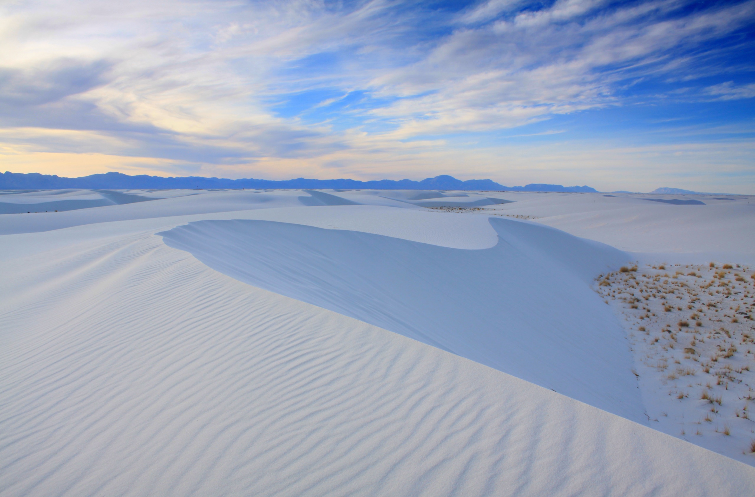 Where to Enjoy the Great Outdoors as a Healthcare Traveler Expansive white gypsum sand dunes under a bright blue sky at White Sands National Park, New Mexico