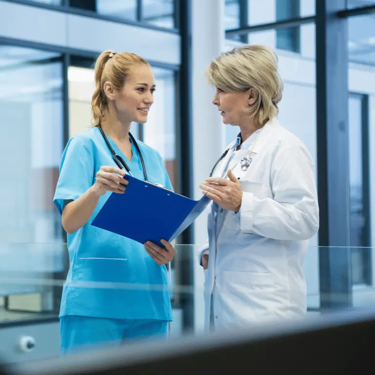Nurse and physician reviewing patient information together in a healthcare facility.