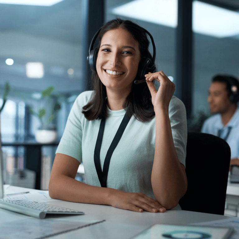 Clinical call center professional wearing a headset while assisting members in a modern office.