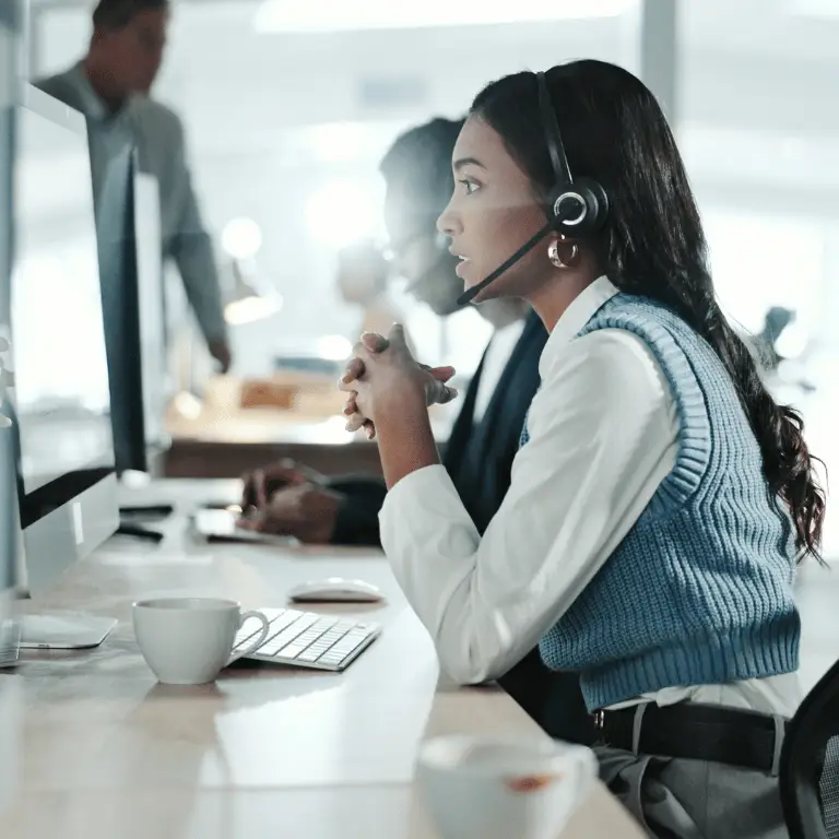 Health plan professional wearing a headset assisting a member while working at a computer.