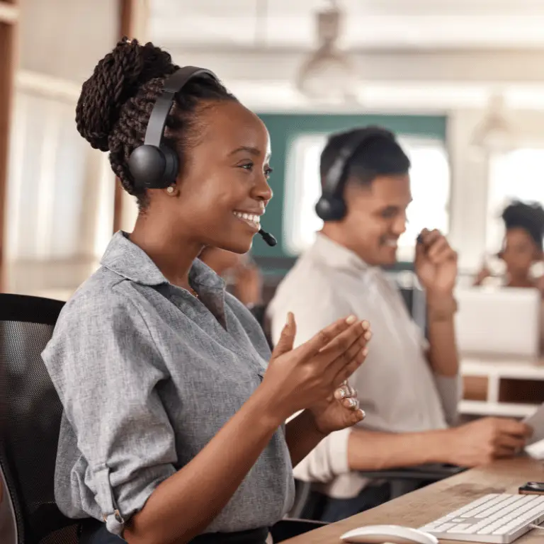 Customer service professional wearing a headset assisting clients in a collaborative office environment.