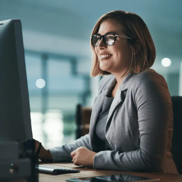 Professional working at a computer in a modern healthcare office setting.