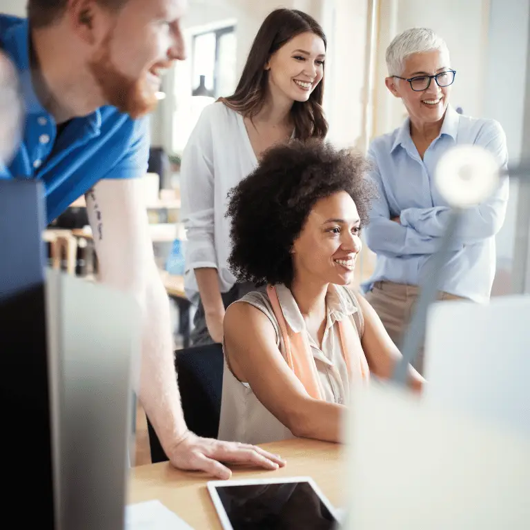Healthcare professionals collaborating around a computer in a bright, modern office.