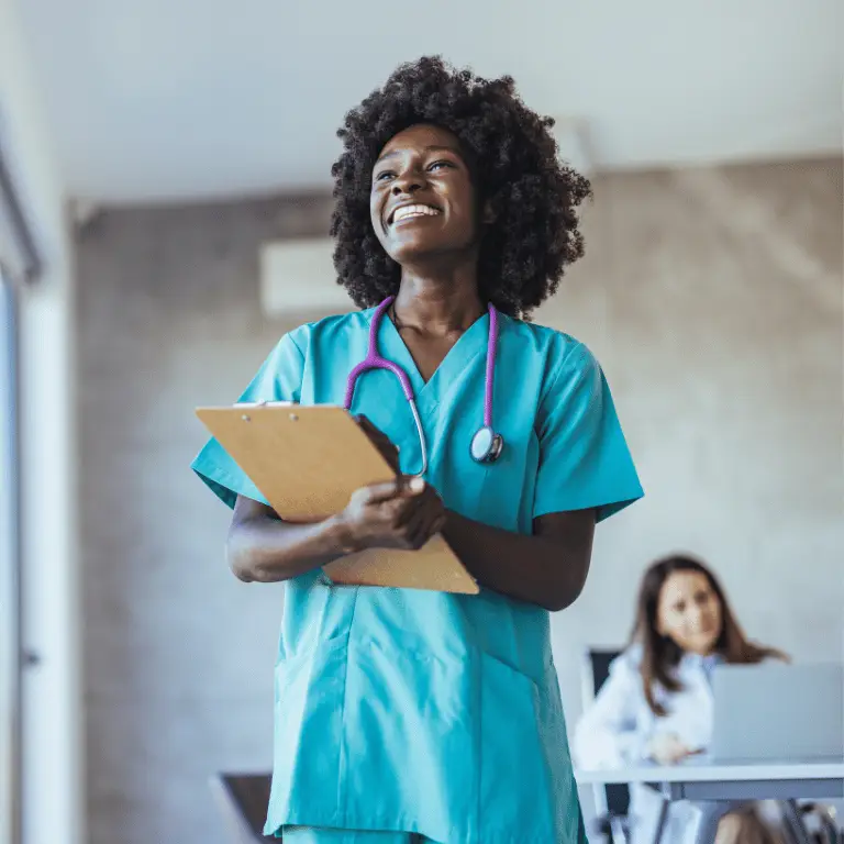 Nurse in teal scrubs with a stethoscope holding a clipboard in a healthcare facility.