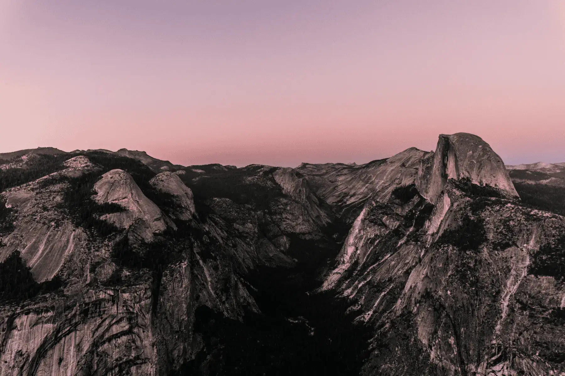 5 Mountainous National Parks and Top Hikes for the Best Views view of a mountainous valley during sunset with a pink glow