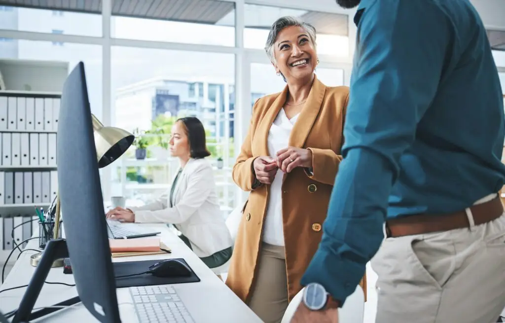 employees talking at computer