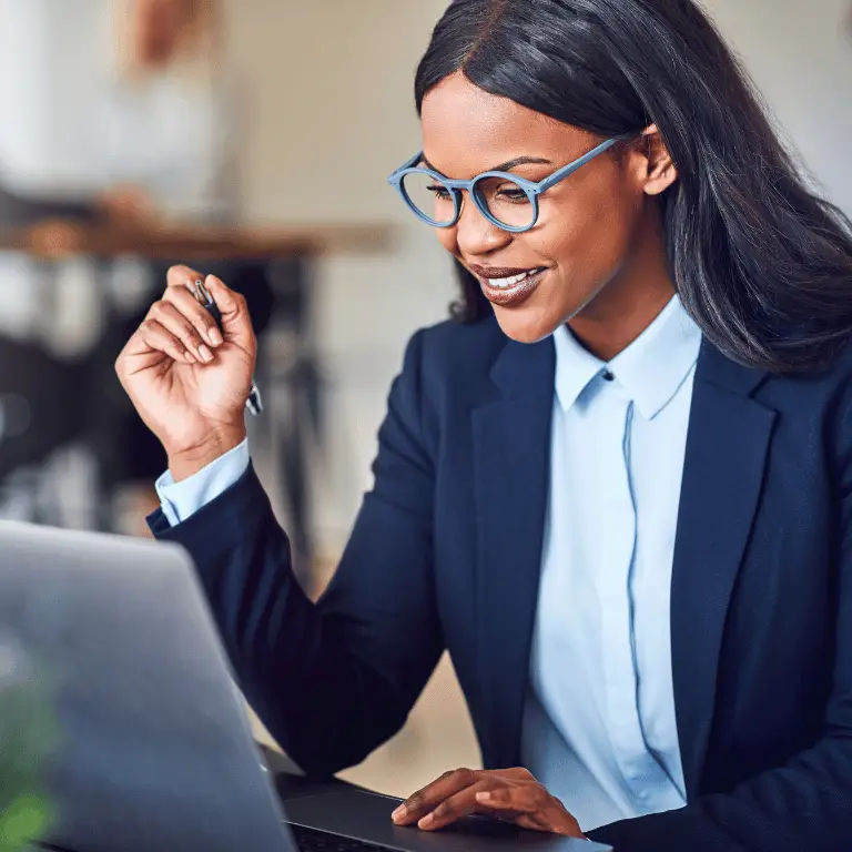 Business professional reviewing information on a laptop while working in a modern office setting.